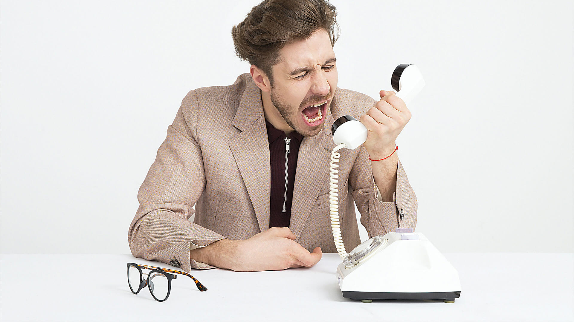 Mann schreit in Telefon, weil er einen Werbeanruf erhalten hat