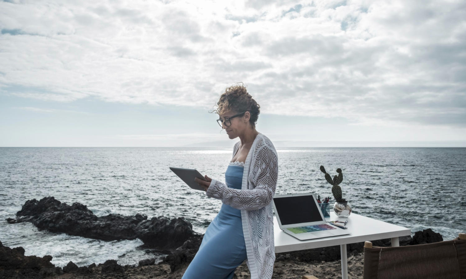 Workation: Junge Frau arbeitet mit Laptop am Urlaubsort